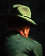 American Art: detail of a Hopper painting, showing a hatted man, back to viewer, half in deep shadow, half in sharp, raking light
