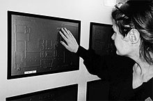 Woman touching tactile map of museum.